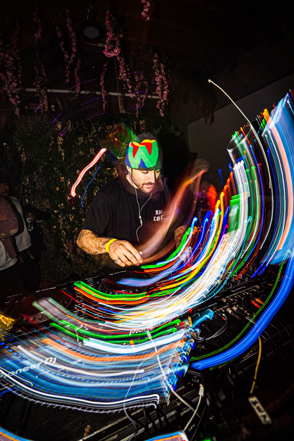 A DJ surrounded by multicolored light trails