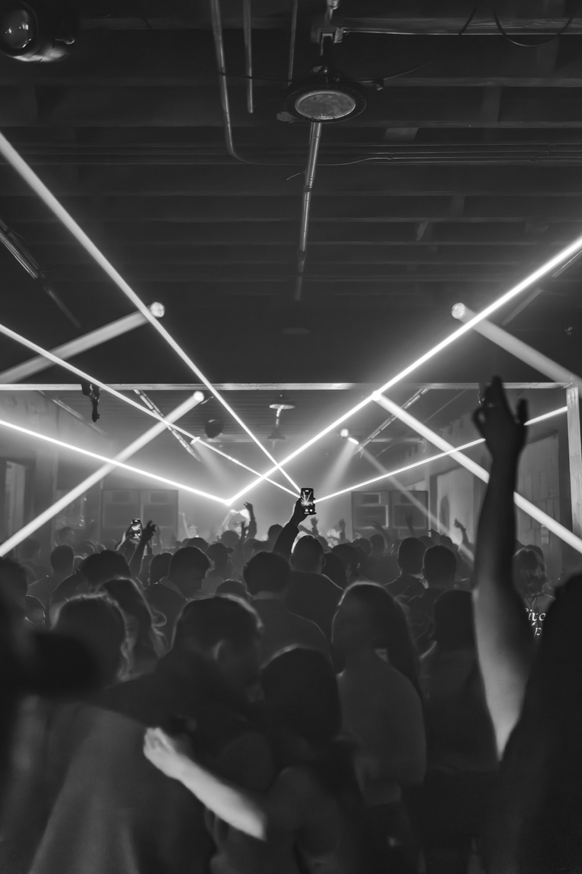 A black and white dance floor lit by crossing beams