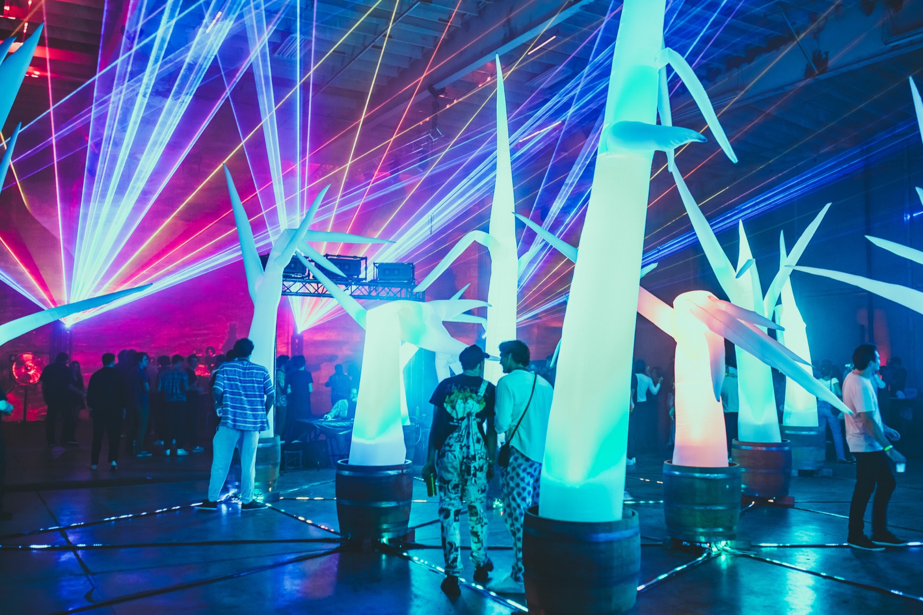 Inflatable trees and laser lights filling a warehouse