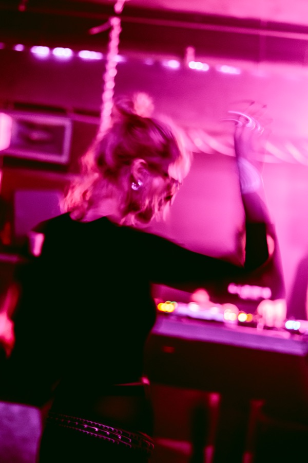 Guest dancing beneath magenta light